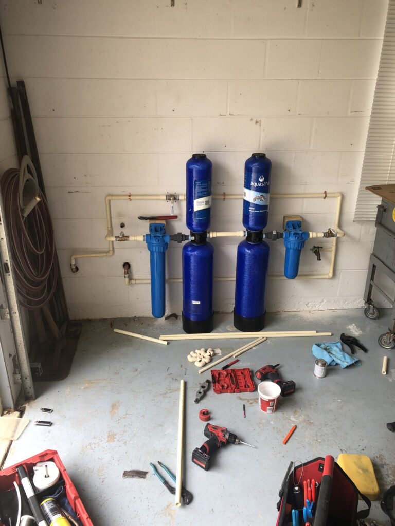 Whole-house water treatment system installed on a garage wall in Palm Coast