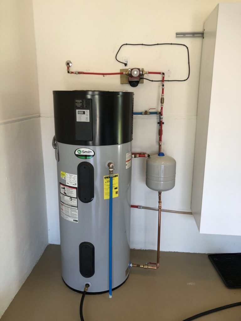 Rheem hybrid heat pump water heater installed in a Florida garage with expansion tank and condensate line