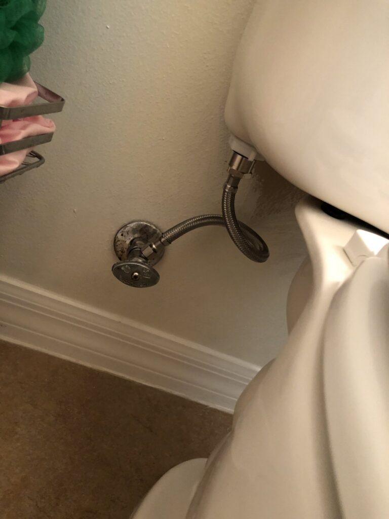 Toilet supply stop and braided line behind a toilet in Palm Coast