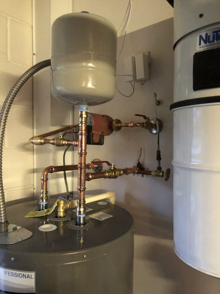 Water heater top connections with expansion tank and recirculating pump