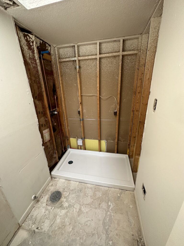 Shower pan and drain rough-in in a gutted Palm Coast bathroom