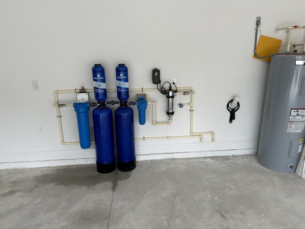 Whole-house carbon filtration tank installed with a sediment pre-filter in a Palm Coast garage